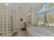 Elegant bathroom with soaking tub, glass block shower, and large window at 910 Park Place Dr, Englewood, FL 34223