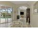 Bright dining area with glass-top table and white metal chairs, view to pool at 910 Park Place Dr, Englewood, FL 34223