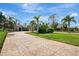 Long driveway leading to a beautiful home with palm trees at 910 Park Place Dr, Englewood, FL 34223