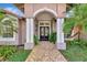 Inviting exterior with a covered entry and lush landscaping at 910 Park Place Dr, Englewood, FL 34223