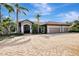 Three-car garage and circular driveway in front of house at 910 Park Place Dr, Englewood, FL 34223