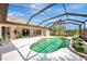 Inviting kidney-shaped pool with a screened enclosure and patio furniture at 910 Park Place Dr, Englewood, FL 34223