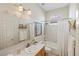 Well-lit bathroom with a single sink vanity, tub and shower combo, and neutral finishes at 9860 Eagle Preserve Dr, Englewood, FL 34224