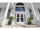 Grand entrance featuring double doors, transom window, and lush potted plants adding curb appeal at 9860 Eagle Preserve Dr, Englewood, FL 34224