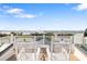 Rooftop view, featuring chairs and table overlooking a body of water and other houses at 9860 Eagle Preserve Dr, Englewood, FL 34224