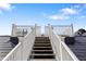 Stairway leading to roof deck, featuring white railings and steps at 9860 Eagle Preserve Dr, Englewood, FL 34224