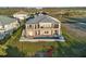 Aerial view of the two-story home featuring backyard pool, lawn, and partial golf course view at 9861 Eagle Preserve Dr, Englewood, FL 34224