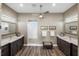 This bathroom is adorned with double vanity sinks, wood look floors, and a glass enclosed shower at 9861 Eagle Preserve Dr, Englewood, FL 34224