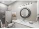 Clean bathroom with a shower, white vanity, and decorative artwork at 9861 Eagle Preserve Dr, Englewood, FL 34224