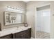 This bathroom boasts a dual vanity, and a glass shower with stone floors and walls at 9861 Eagle Preserve Dr, Englewood, FL 34224