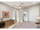 Bedroom with wood floors, ceiling fan, and a hallway to the bathroom with double vanity at 9861 Eagle Preserve Dr, Englewood, FL 34224