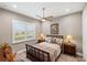 Cozy bedroom with a view of a pond, neutral colors, and lamps on bedside tables at 9861 Eagle Preserve Dr, Englewood, FL 34224