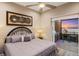 Comfortable bedroom featuring a king-sized bed and access to a terrace with sunset lake views at 9861 Eagle Preserve Dr, Englewood, FL 34224