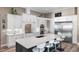 Modern kitchen boasts white cabinets, stainless steel appliances, and a large island with bar seating at 9861 Eagle Preserve Dr, Englewood, FL 34224