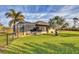 Spacious backyard with screened enclosure, lush lawn, and palm trees at 1 Calm Ct, Placida, FL 33946