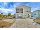 Elevated home with light beige siding, screened porch, and paved driveway at 10451 Sherman St, Englewood, FL 34224