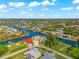 Aerial view of a waterfront house with canal access and lush landscaping at 10544 Poughkeepsie Cir, Port Charlotte, FL 33981