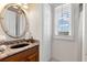 Elegant bathroom with granite vanity, large mirror, and window with plantation shutters at 10544 Poughkeepsie Cir, Port Charlotte, FL 33981