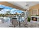 Outdoor seating area with glass table and fireplace near the pool at 10544 Poughkeepsie Cir, Port Charlotte, FL 33981