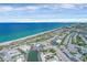 Stunning aerial view of the beachfront property with beautiful ocean and nearby shops at 1100 Gulf Blvd, Englewood, FL 34223