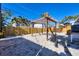 Outdoor backyard space featuring a wooden fence, wood pergola, and an open sandy lot at 1100 Gulf Blvd, Englewood, FL 34223