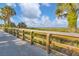 Inviting beach boardwalk with wooden railings and lush tropical landscaping at 1100 Gulf Blvd, Englewood, FL 34223