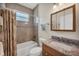 Bathroom with tub, shower, granite countertop, and wood cabinets at 12075 Duval Blvd, Port Charlotte, FL 33981