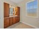 Bathroom with wood cabinets, granite countertop, and large window at 12075 Duval Blvd, Port Charlotte, FL 33981