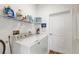 Efficient laundry room features a washer, dryer, storage shelves, and essential cleaning supplies at 12075 Duval Blvd, Port Charlotte, FL 33981