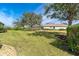 Large backyard with lush grass and mature trees at 12650 Montigello Ct, Englewood, FL 34223