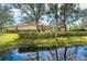 Waterfront backyard with lush landscaping and trees at 12650 Montigello Ct, Englewood, FL 34223