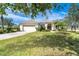 Single-story house with beige exterior and lush landscaping at 12650 Montigello Ct, Englewood, FL 34223