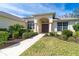 Landscaped front yard with a walkway leading to the arched entryway of a house at 12650 Montigello Ct, Englewood, FL 34223