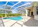 Relaxing kidney-shaped pool with a screened enclosure and paver deck at 12650 Montigello Ct, Englewood, FL 34223