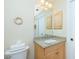 Clean bathroom with granite countertop, light wood cabinets, and a large mirror at 129 Preserve Pl # A, Nokomis, FL 34275