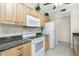 Well-equipped kitchen featuring granite countertops, white appliances, and wooden cabinets at 129 Preserve Pl # A, Nokomis, FL 34275