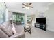 Bright living room featuring a comfy sofa, flat-screen TV, and access to a patio at 129 Preserve Pl # A, Nokomis, FL 34275