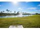 Serene lake view with lush landscaping and fountain at 13489 Abercrombie Dr, Englewood, FL 34223