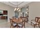 Bright dining room with a wood table and chandelier, view into kitchen at 13760 Long Lake Ln, Port Charlotte, FL 33953