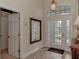 View of the entryway with a large mirror, tiled floor, and a door with beveled glass at 13760 Long Lake Ln, Port Charlotte, FL 33953