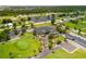 Aerial view of community features including clubhouse, golf course, and tennis courts at 142 Caddy Rd, Rotonda West, FL 33947