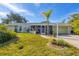 Single story home with light colored exterior, screened porch, and well-manicured lawn at 142 Caddy Rd, Rotonda West, FL 33947