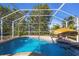 Inviting screened pool with a tiki umbrella at 142 Caddy Rd, Rotonda West, FL 33947