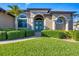 Teal double front doors, arched entryway, and manicured hedges at 14201 Joggins Ave, Port Charlotte, FL 33981