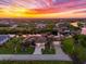 Stunning aerial view of canal-front home with lush landscaping and sunset at 14216 Aurella Cir, Port Charlotte, FL 33981