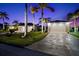 Two-car garage with well manicured lawn and tropical landscaping at 14216 Aurella Cir, Port Charlotte, FL 33981