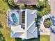 Aerial view of a modern home with a screened-in pool, solar panels, and a well-manicured yard with beautiful landscaping at 1443 Quail Lake Dr, Venice, FL 34293