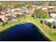 A scenic aerial view of a community with houses surrounding a lake in a lush, green landscape at 1443 Quail Lake Dr, Venice, FL 34293