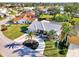 Aerial view of one-story home on a large lot with lush, tropical landscaping and mature palm trees at 1443 Quail Lake Dr, Venice, FL 34293