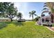 Beautiful green backyard with mature trees and landscaping offers a view of the screened in-ground pool at 1443 Quail Lake Dr, Venice, FL 34293